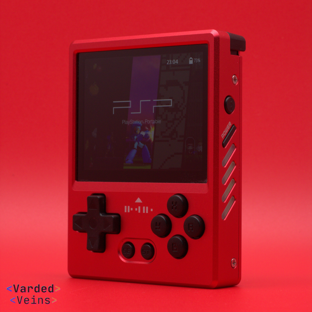 Red GKDPixel2 handheld gaming console with screen displaying a game on a red background