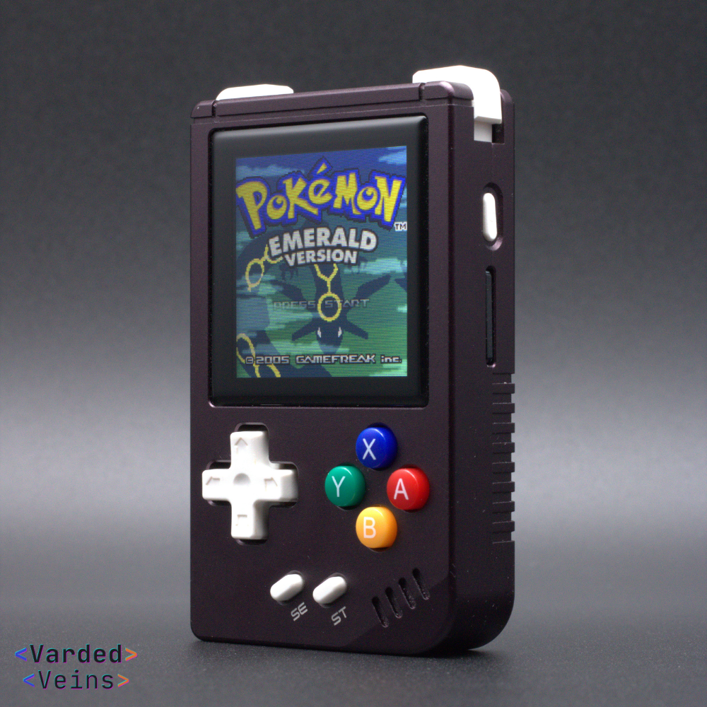 Handheld gaming console displaying 'Pokémon Emerald Version' on a dark background